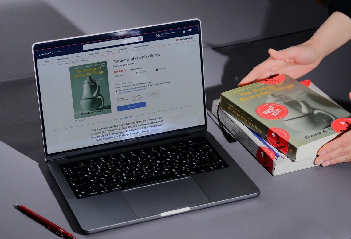 The Bookster shop open on a laptop, with a stack of books beside it